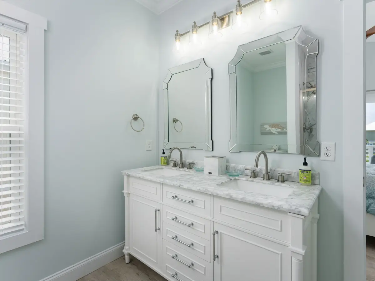 Elegant primary bathroom with double vanity and upscale coastal finishes at A Sail Away.