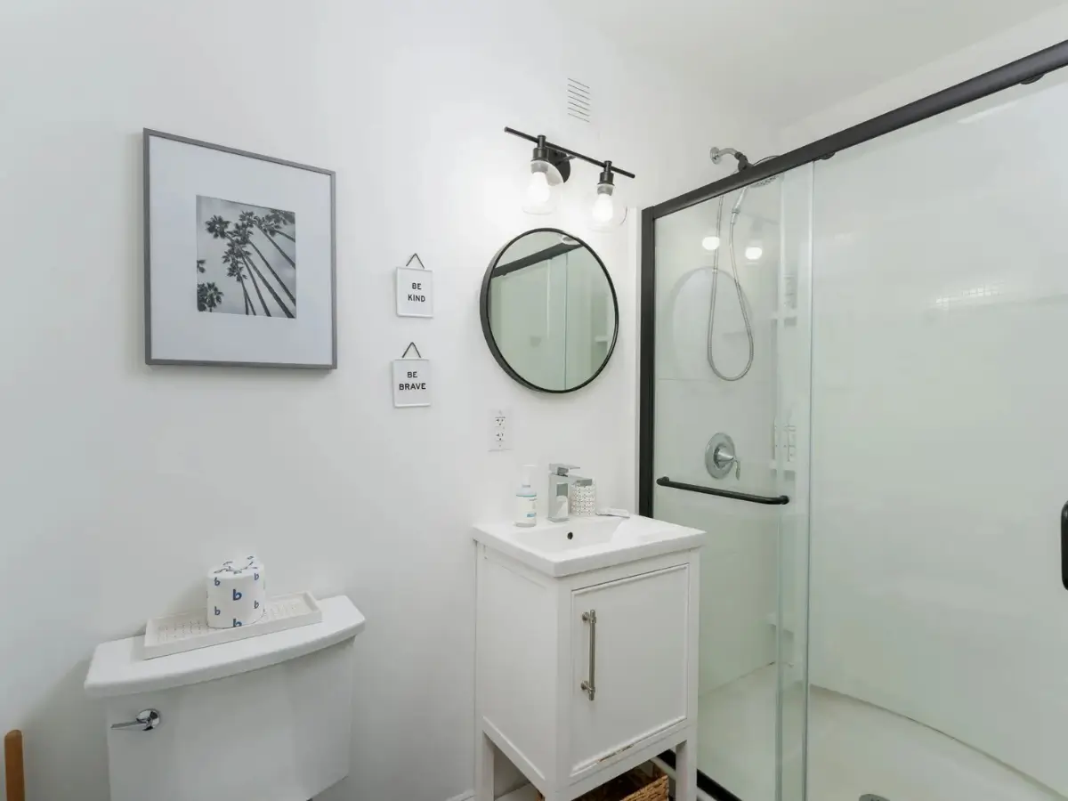 Updated bathroom with walk-in glass shower, modern vanity, and bright coastal finishes.