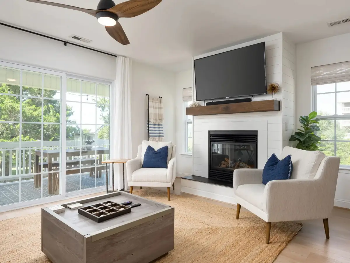 Bright coastal living room with fireplace, comfortable seating, and access to the outdoor deck at Salty Dream.