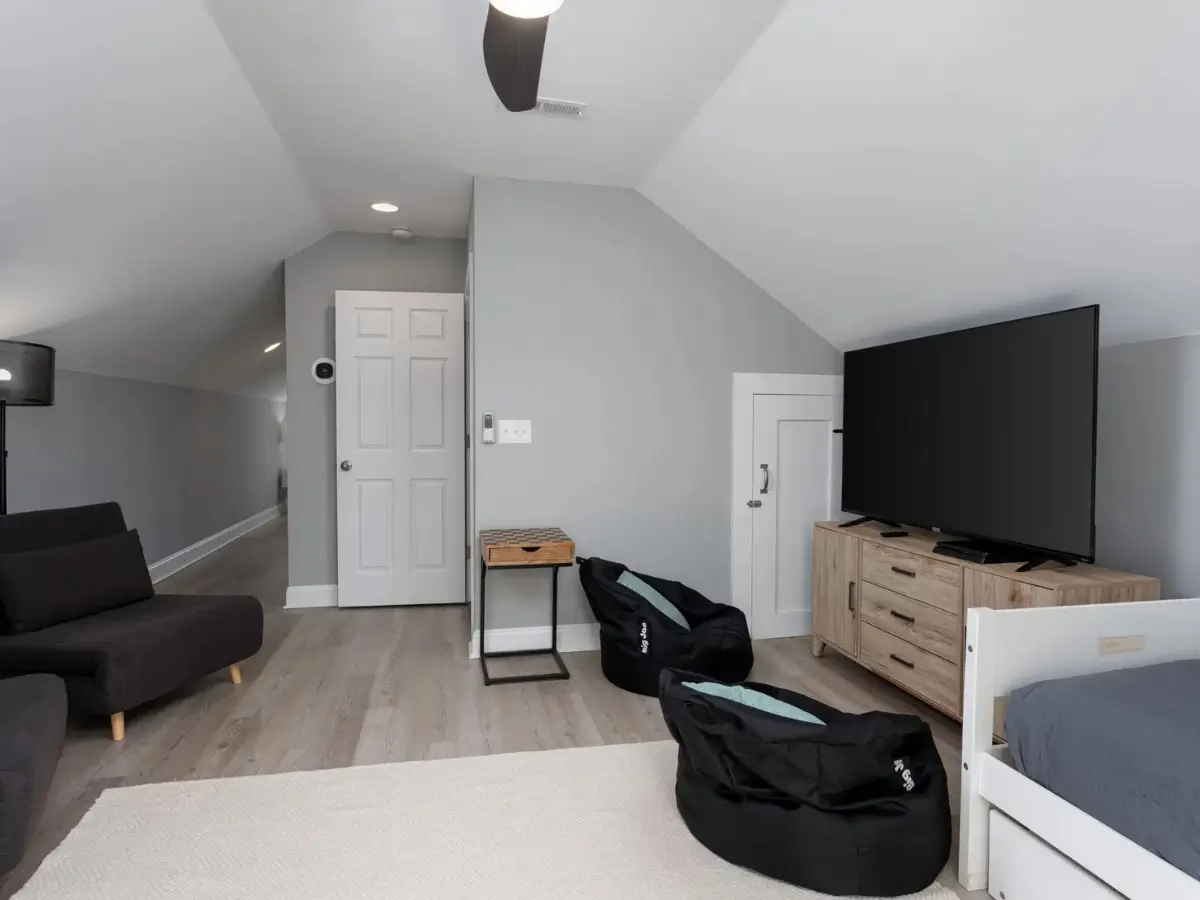 Spacious loft featuring lounge seating, TV, bean bags, and sleeping accommodations for families.