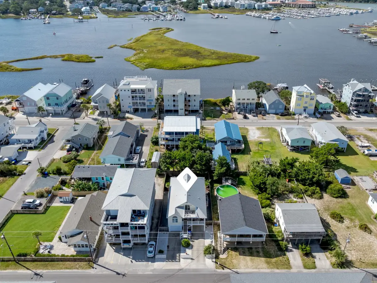 Drone view of Salty Dream surrounded by Ocean Isle Beach homes and nearby waterways.