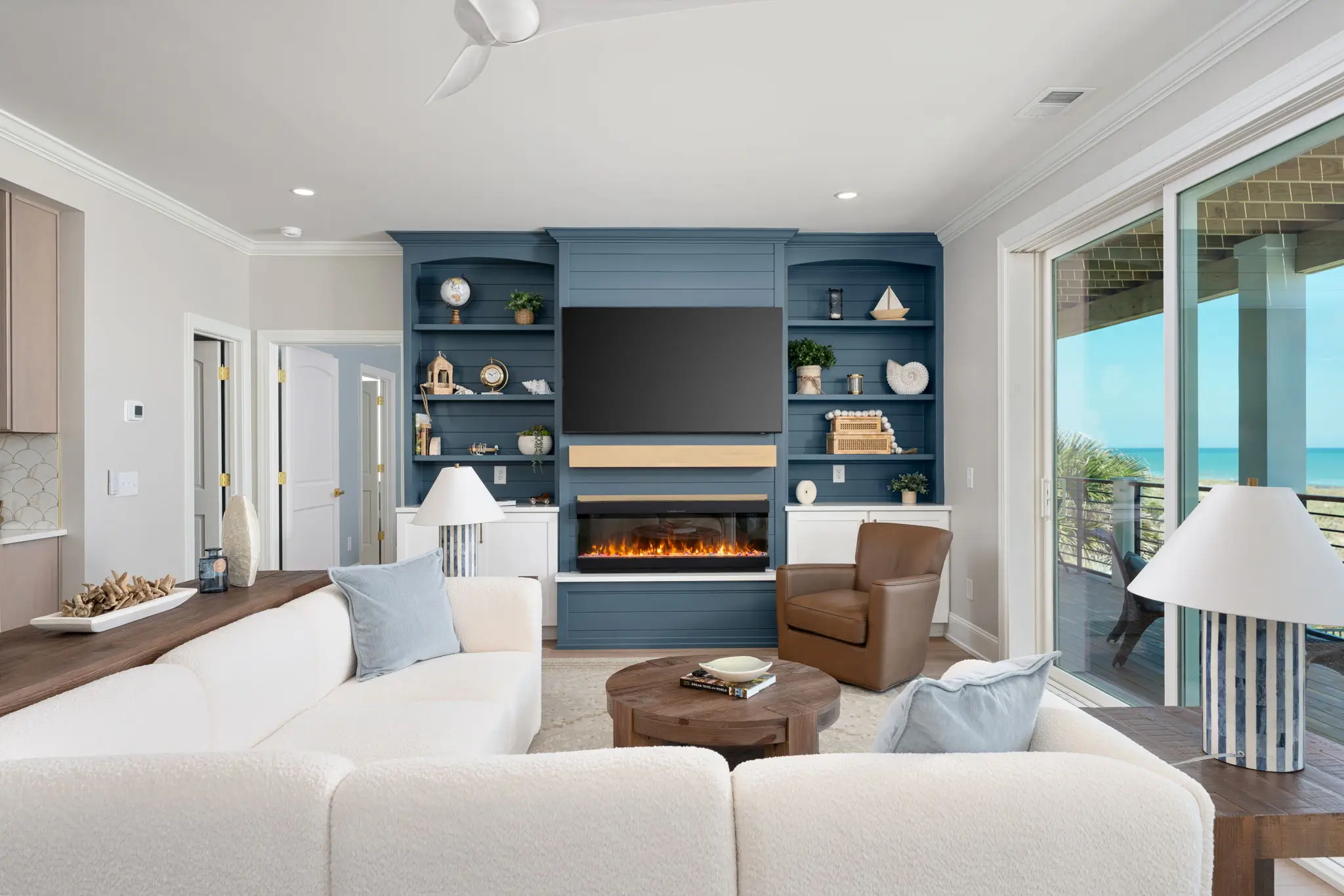 Coastal living room with fireplace, built-in shelving, and ocean views