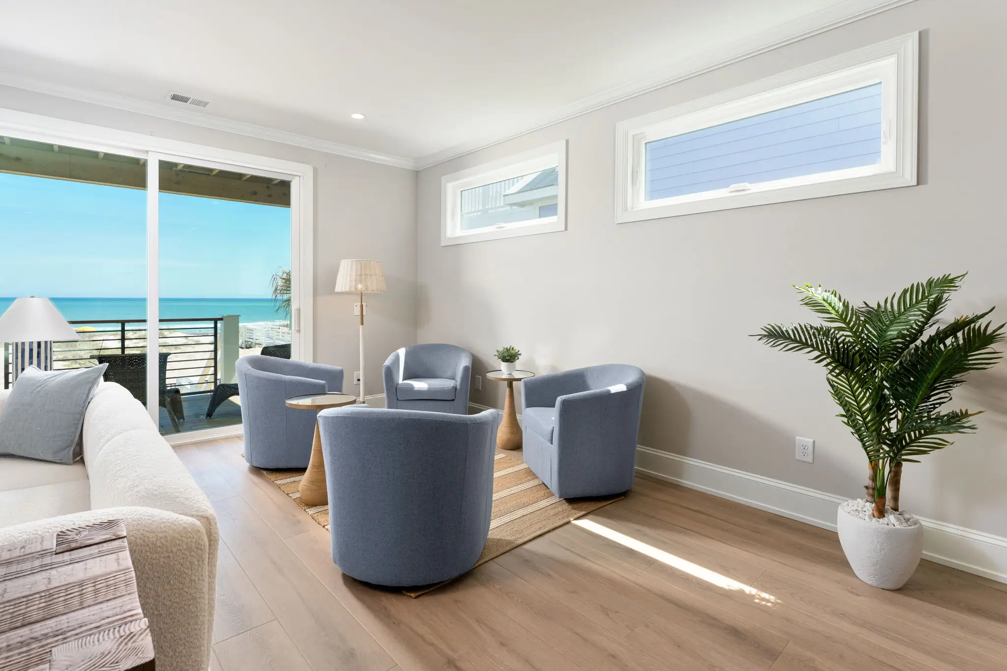 Bright ocean-view living room with sliding doors leading to the deck