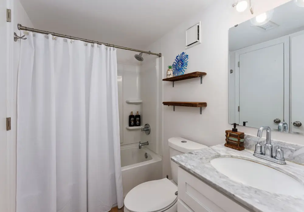 Bright full bathroom with tub and shower at The Sunshine Shack in Carolina Beach