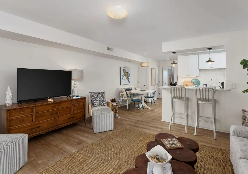 Bright coastal living room with TV and open kitchen at The Sunshine Shack