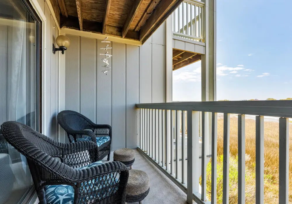 Covered rear porch with seating and peaceful marsh views