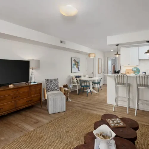 Bright coastal living room with TV and open kitchen at The Sunshine Shack